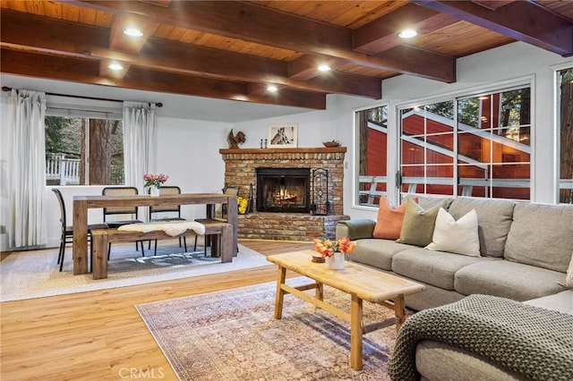 living room with a fireplace, hardwood / wood-style floors, beam ceiling, and wooden ceiling