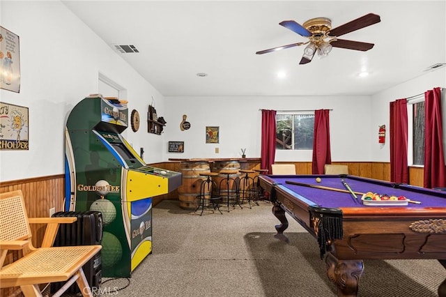 game room featuring billiards, ceiling fan, wooden walls, carpet floors, and indoor bar