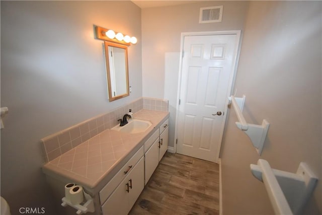 bathroom with vanity, backsplash, and wood-type flooring