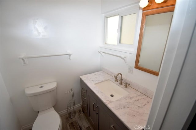 bathroom featuring vanity, toilet, and hardwood / wood-style floors