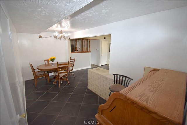 tiled dining room with a textured ceiling and a chandelier