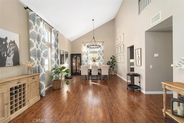 dining room featuring a chandelier, high vaulted ceiling, and dark wood-type flooring