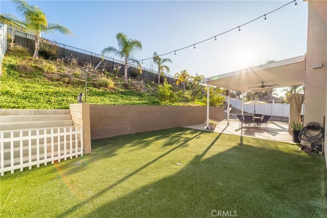 view of yard featuring ceiling fan and a patio