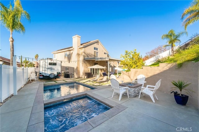 view of pool with a patio area, an in ground hot tub, and an outdoor fire pit