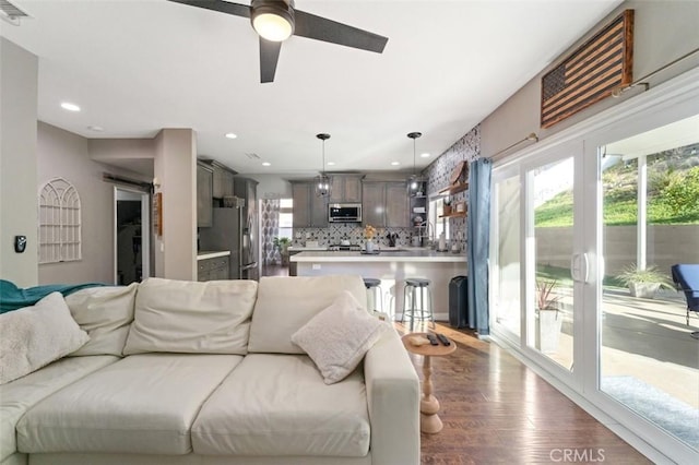 living room featuring ceiling fan and hardwood / wood-style floors