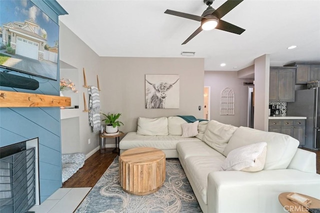 living room featuring ceiling fan and dark wood-type flooring