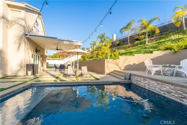 view of swimming pool featuring ceiling fan and a patio