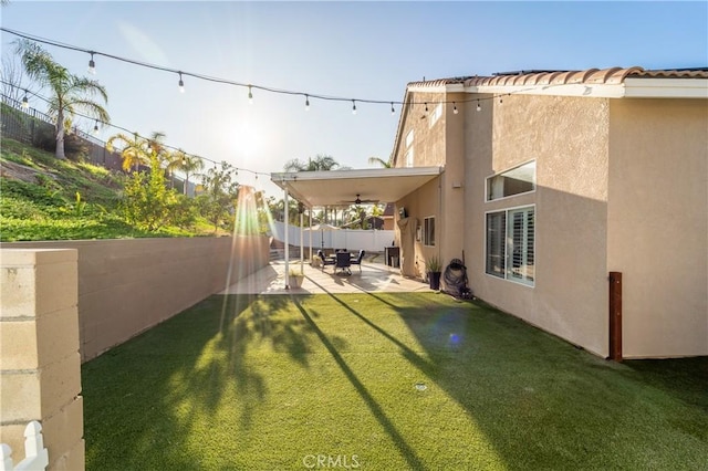 view of yard with ceiling fan and a patio area