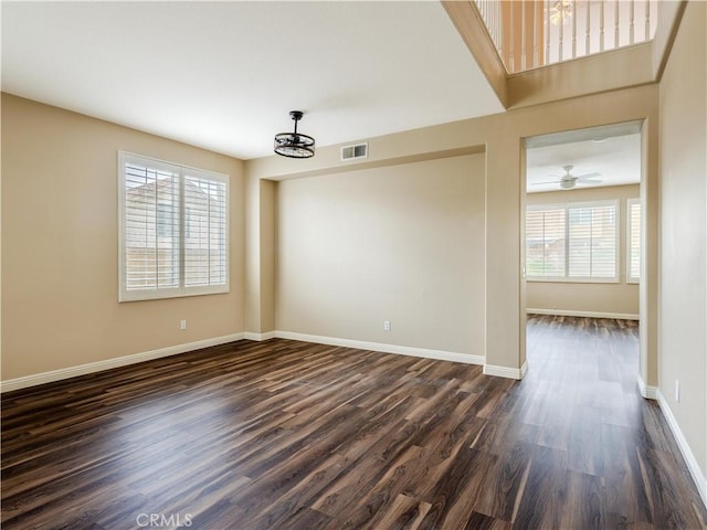 unfurnished room with ceiling fan, dark hardwood / wood-style floors, and a wealth of natural light