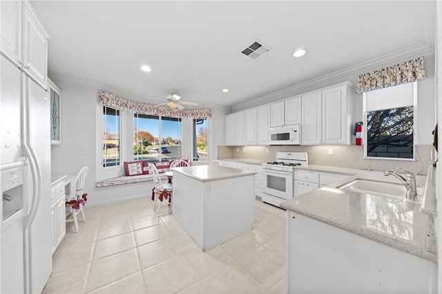 kitchen featuring crown molding, sink, white cabinets, and white appliances