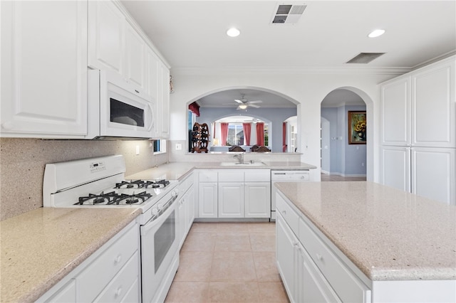 kitchen featuring white appliances, ceiling fan, crown molding, light tile patterned floors, and white cabinetry