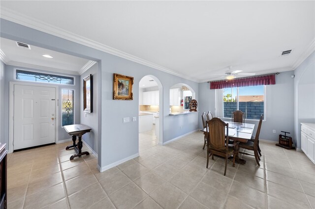 dining area featuring ceiling fan, crown molding, and light tile patterned flooring