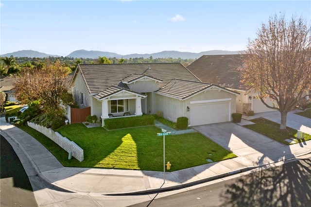 single story home featuring a mountain view, a garage, and a front yard