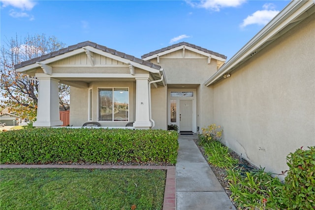 view of exterior entry with a lawn