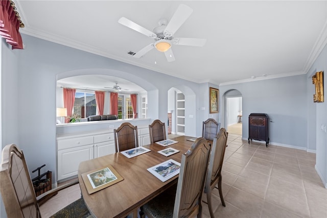 tiled dining room with built in shelves, crown molding, and ceiling fan