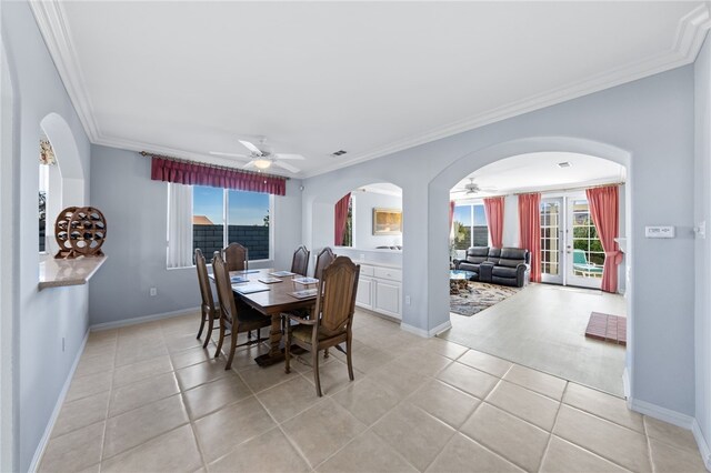 tiled dining area featuring ceiling fan, ornamental molding, and french doors