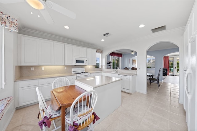 kitchen with sink, white cabinets, a healthy amount of sunlight, and white appliances