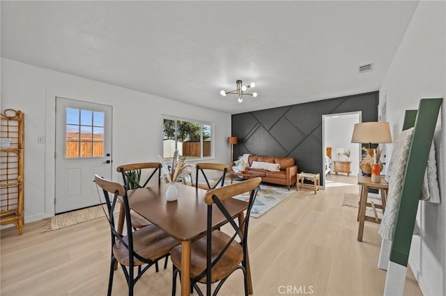 dining area featuring light hardwood / wood-style flooring and a chandelier