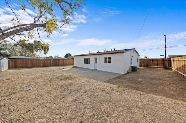 back of property with central AC unit and a patio