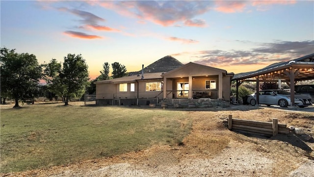 view of front of house with a carport and a lawn