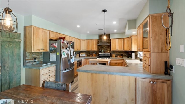 kitchen with wall chimney exhaust hood, sink, decorative backsplash, and stainless steel appliances