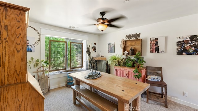 dining space featuring light colored carpet and ceiling fan