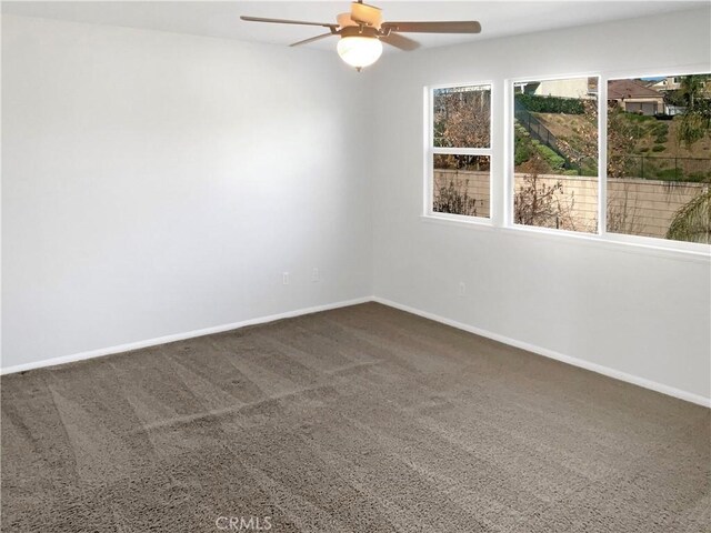 carpeted spare room with ceiling fan