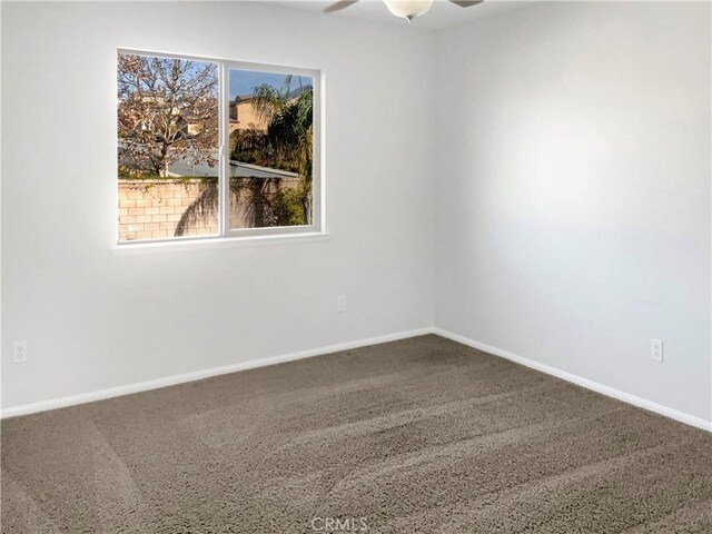 carpeted spare room featuring ceiling fan and a healthy amount of sunlight