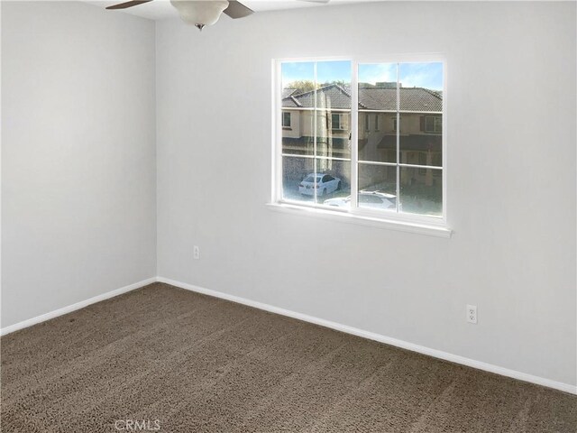 spare room with ceiling fan and carpet