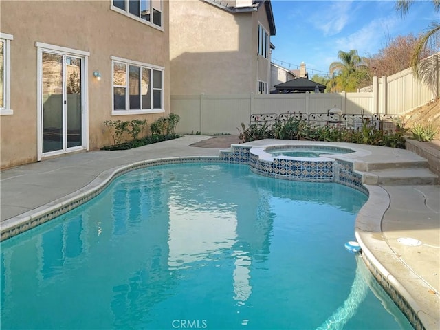 view of pool featuring a pool with connected hot tub, a fenced backyard, and a patio