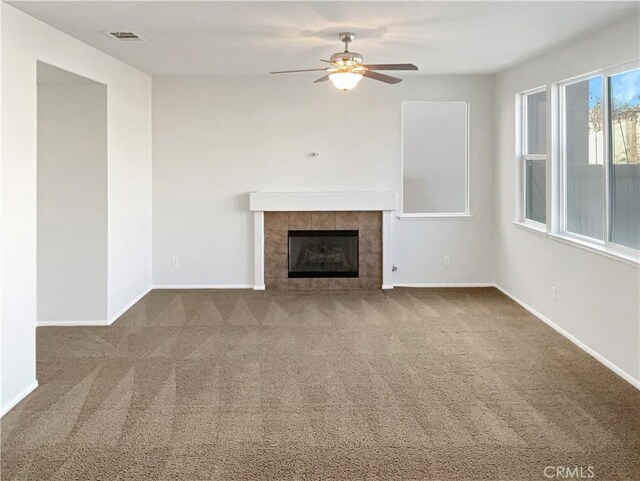 unfurnished living room with carpet flooring, ceiling fan, and a tile fireplace