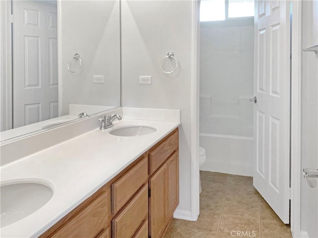 bathroom featuring double vanity, tile patterned flooring, a sink, and toilet