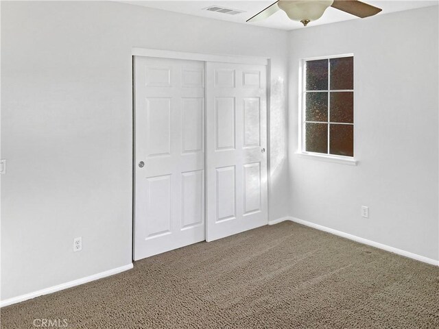 unfurnished bedroom featuring ceiling fan, carpet floors, and a closet