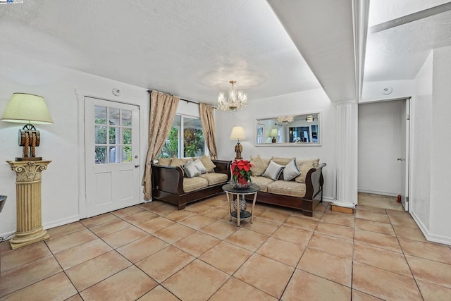 living room with light tile patterned floors, decorative columns, and an inviting chandelier