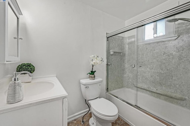 full bathroom featuring vanity, bath / shower combo with glass door, and toilet