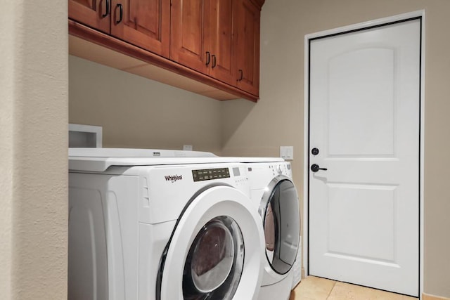 washroom featuring washer and dryer, light tile patterned floors, and cabinets