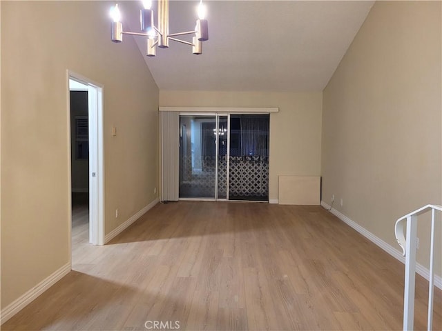 unfurnished room with vaulted ceiling, light wood-type flooring, and an inviting chandelier