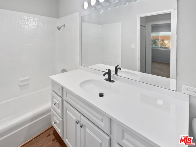 bathroom featuring hardwood / wood-style flooring, vanity, and bathtub / shower combination