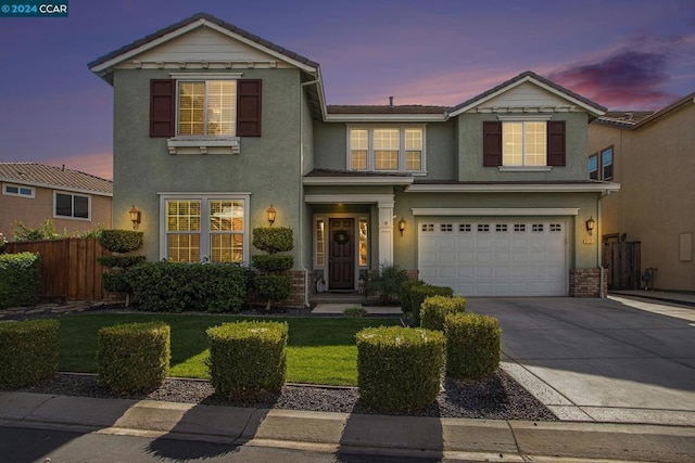 front facade with a garage and a lawn