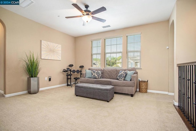 living room with ceiling fan and light colored carpet