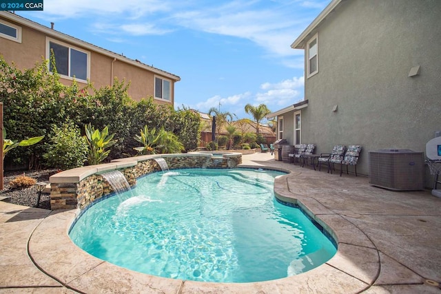 view of pool with an in ground hot tub, central AC, pool water feature, and a patio