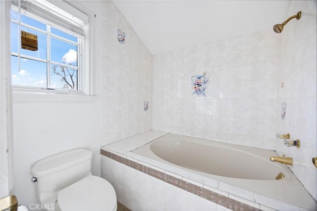 bathroom featuring toilet, lofted ceiling, and tiled shower / bath combo