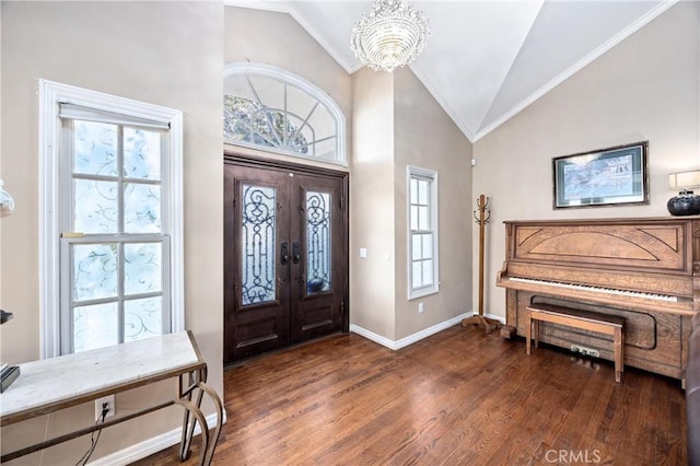 foyer entrance featuring lofted ceiling, french doors, a notable chandelier, and dark hardwood / wood-style flooring