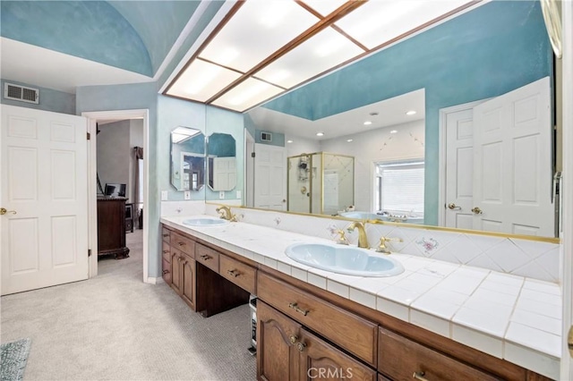 bathroom with an enclosed shower, vanity, and lofted ceiling