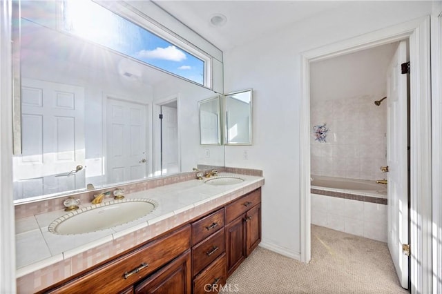 bathroom with tiled shower / bath combo and vanity