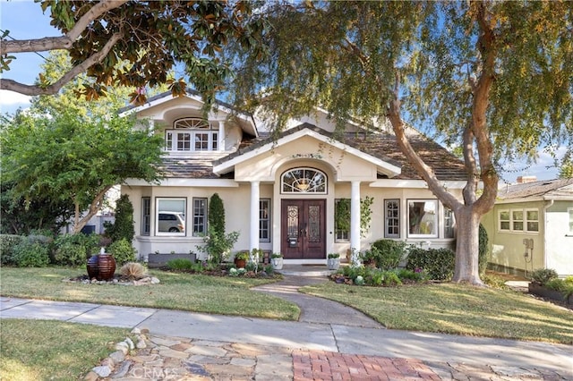 view of front of home with a front yard and french doors