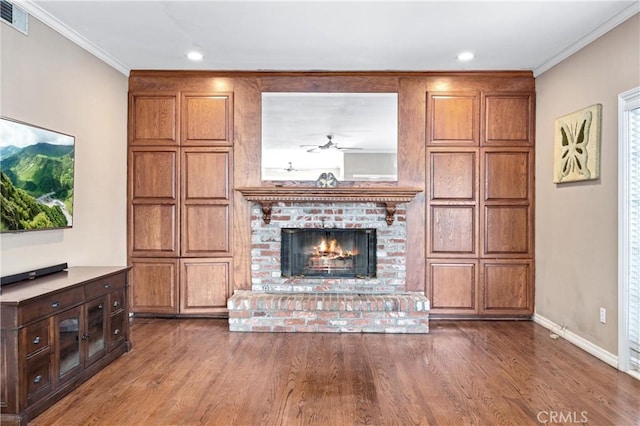 unfurnished living room with ceiling fan, a fireplace, ornamental molding, and dark hardwood / wood-style floors