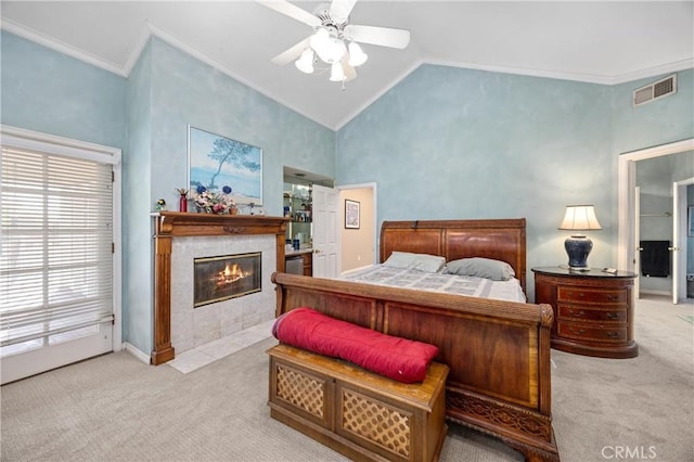 carpeted bedroom featuring ceiling fan, vaulted ceiling, a fireplace, and ornamental molding