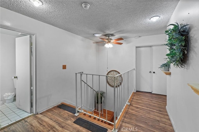 hallway featuring hardwood / wood-style floors and a textured ceiling