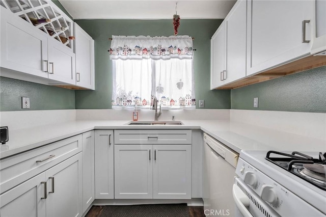 kitchen featuring white cabinetry, sink, and white appliances